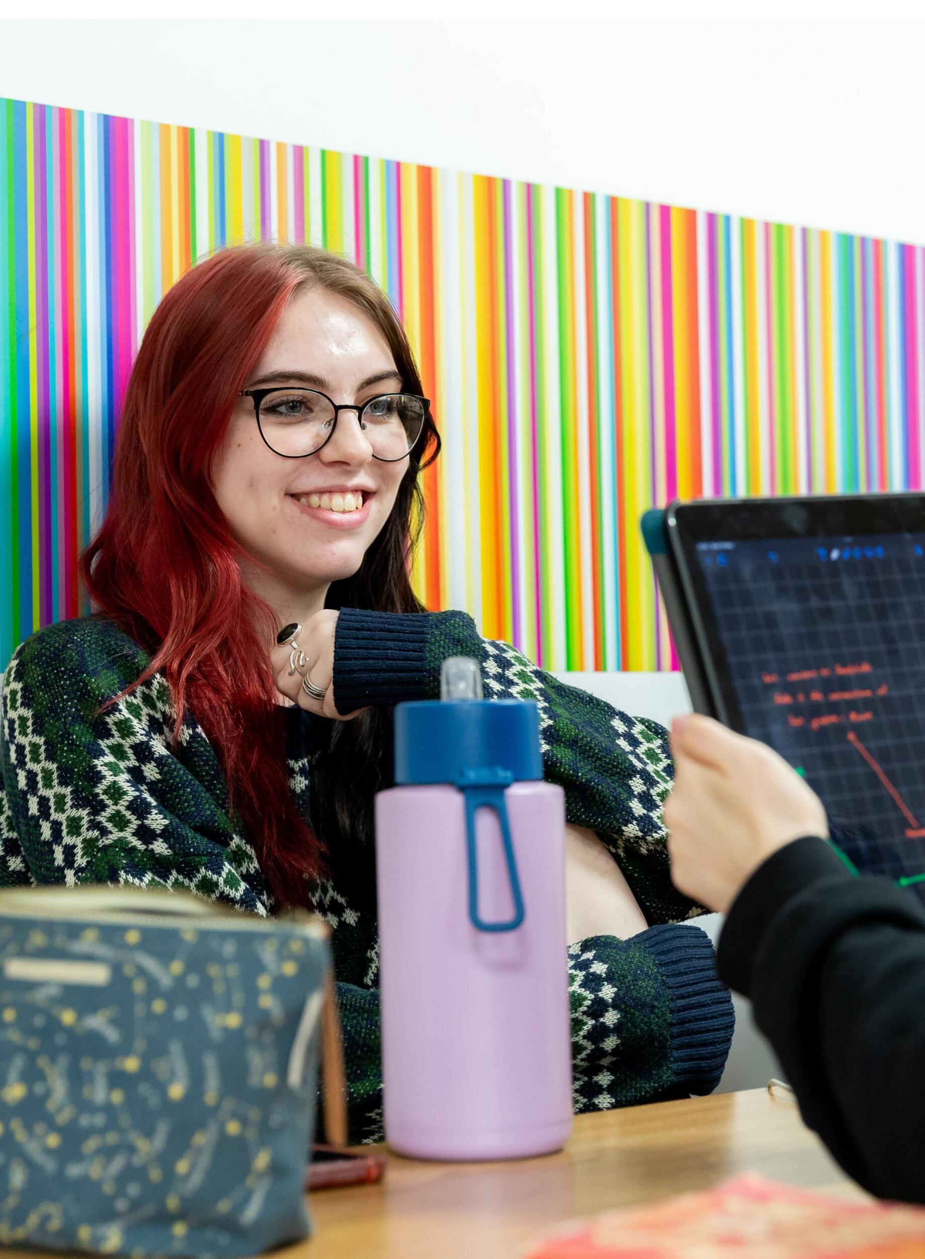 Student smiling opposite someone with a laptop