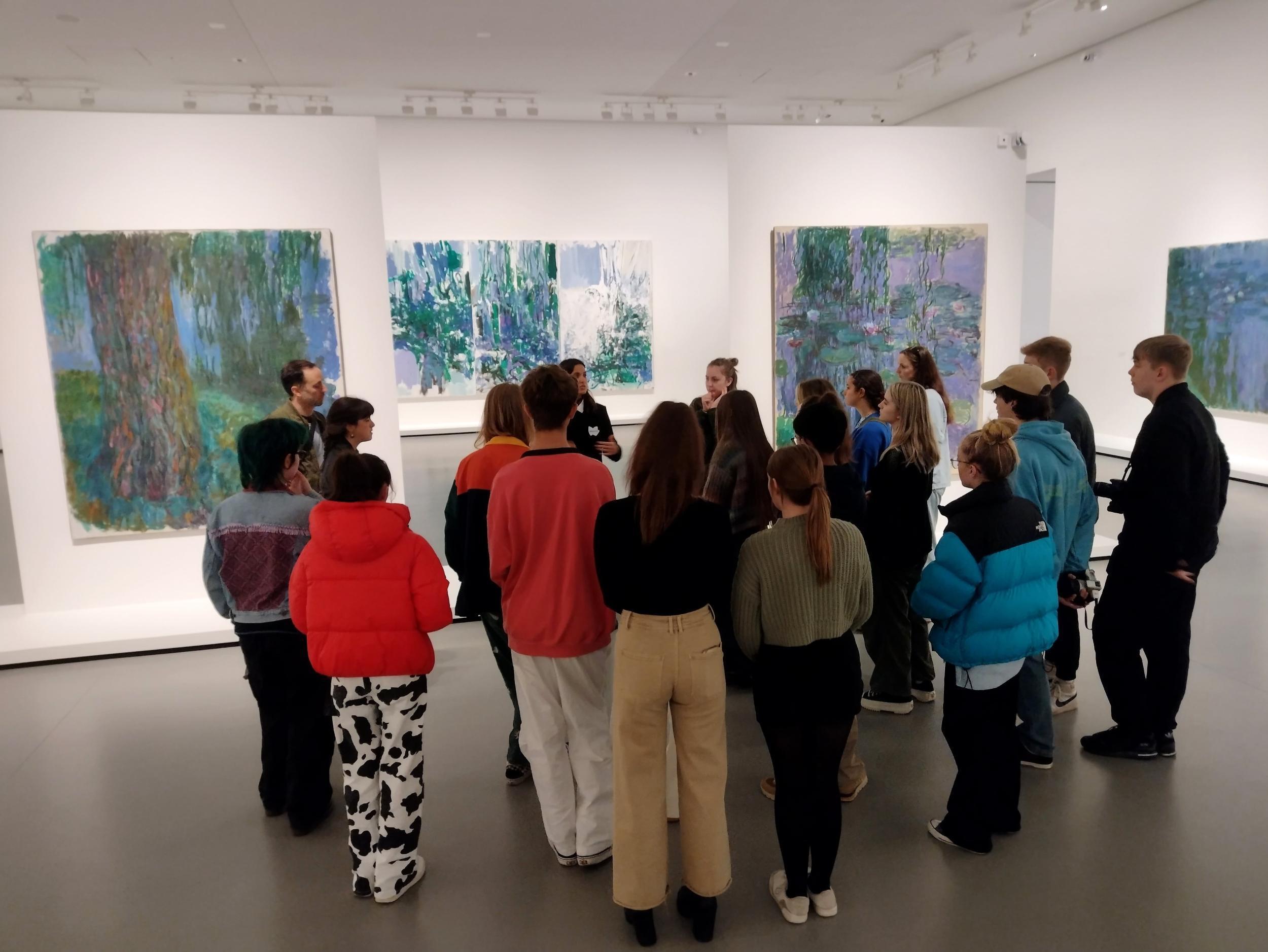 Students in an art gallery looking at artworks