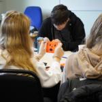 Student holding up a fabric pumpkin face