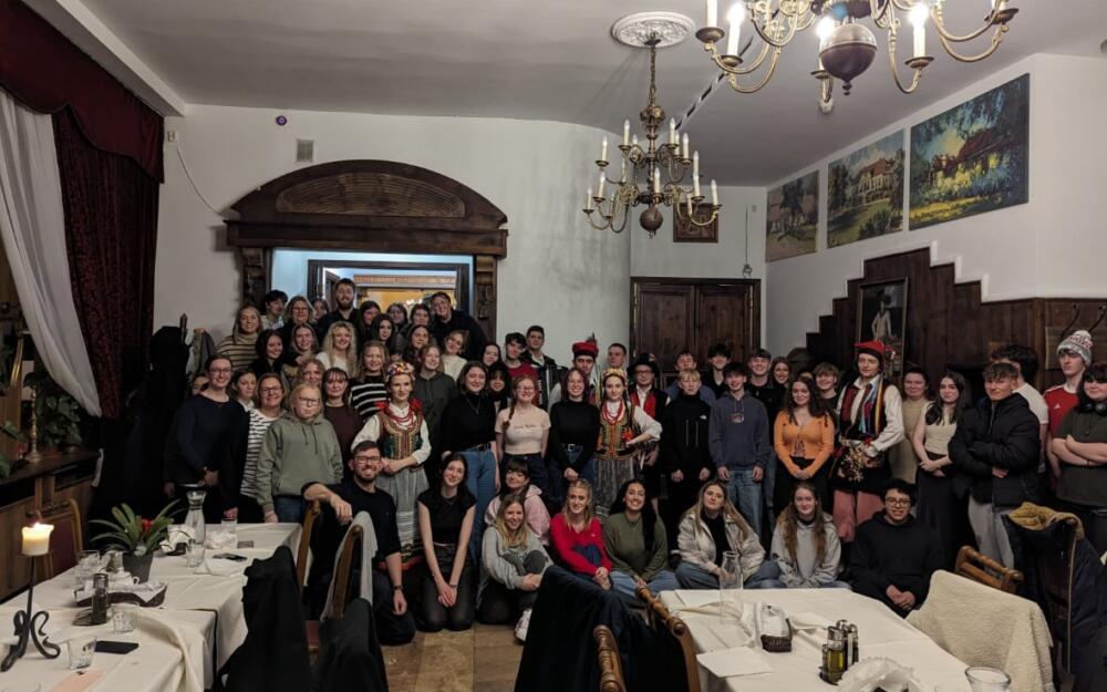 Students in Polish restaurant with people in traditional dress