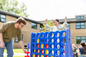 Two students playing a large version of Connect 4.