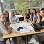 6 members of the Ocean 2 Ocean team sat around a table at Richard Huish College Dragons Den 2024.