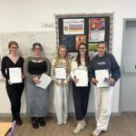 5 students standing up who participated in The Richard Huish College Dragons Den 2024