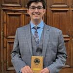 Student Marco Luthra holding his Unsung Heroes of Science award.