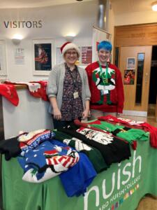 Student and staff stood at stand giving away Christmas jumpers