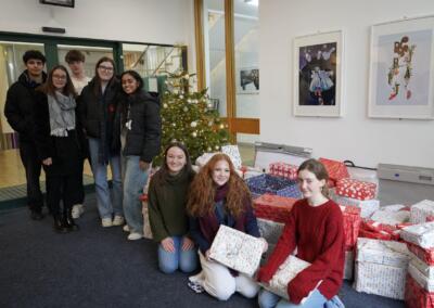 Some students posing with wrapped and packed boxes of donated food items