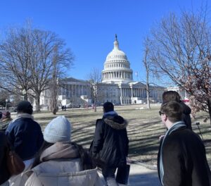 A photo of students walking past Congress in Washington D.C, with blue skies.