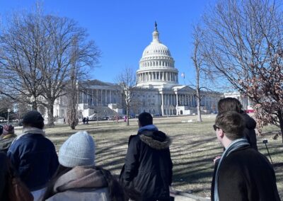 A photo of students walking past Congress in Washington D.C, with blue skies.