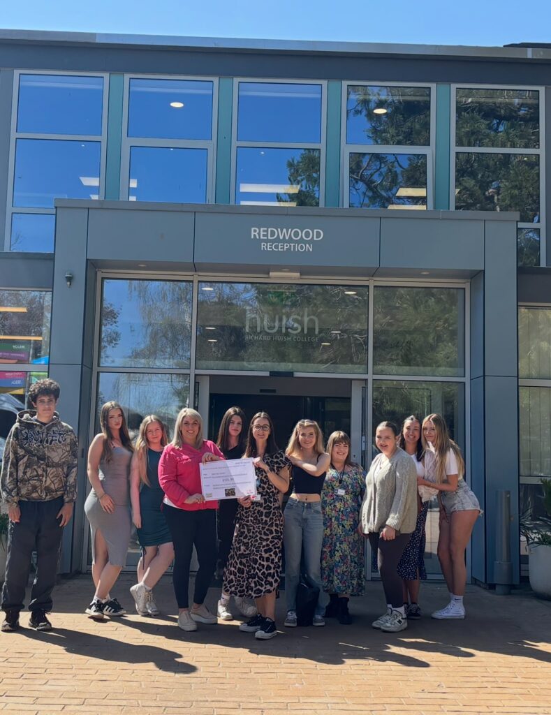 Business, Marketing and Management students presenting a cheque to charity representatives