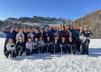 Group of students in an an icy Iceland, holding pick-axes.