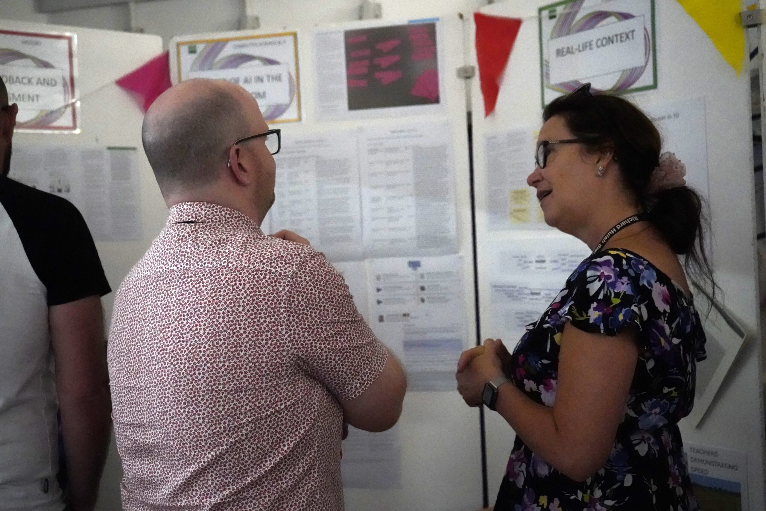 Staff in front of a stall at the action research marketplace.