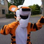 A man in a tiger suit holding an ice cream