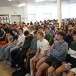 A large group of students listen to a talk