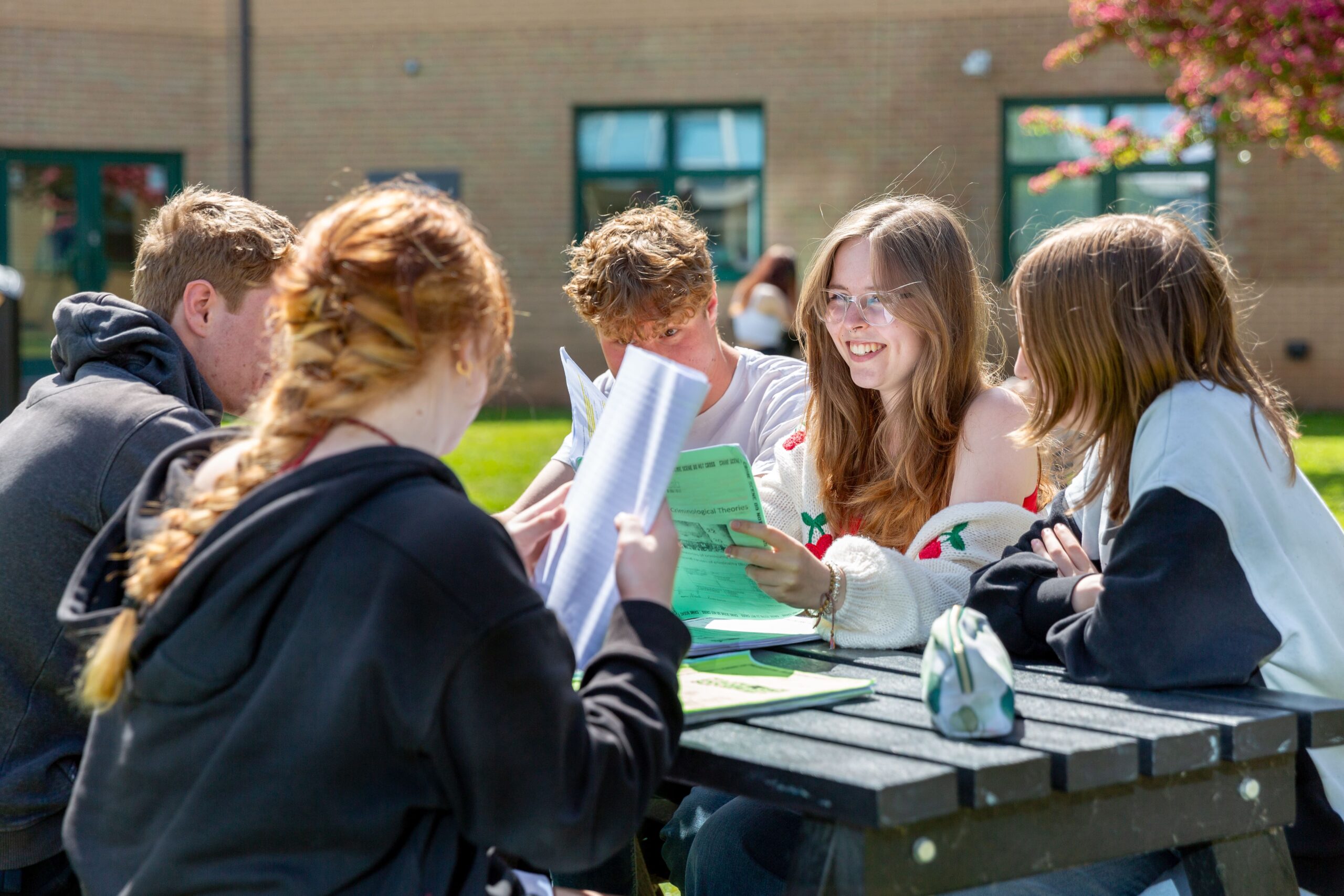 Advice And Guidance Min Students smiling on outside picnic bench