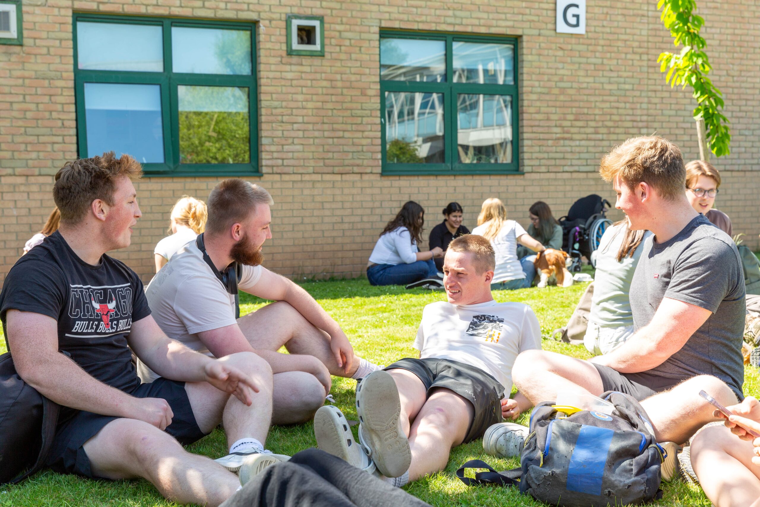 Students sat relaxed outside on grass
