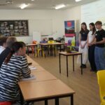 3 students pitching in front of the panel
