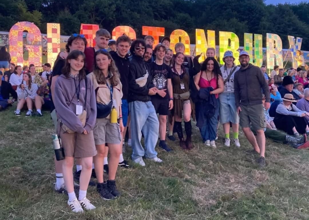 Students stood in front of glastonbury festival sign