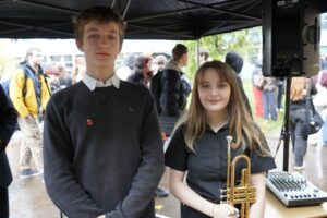 Two students facing the camera. One is holding a trumpet. Both performed in the Remembrance Ceremony.