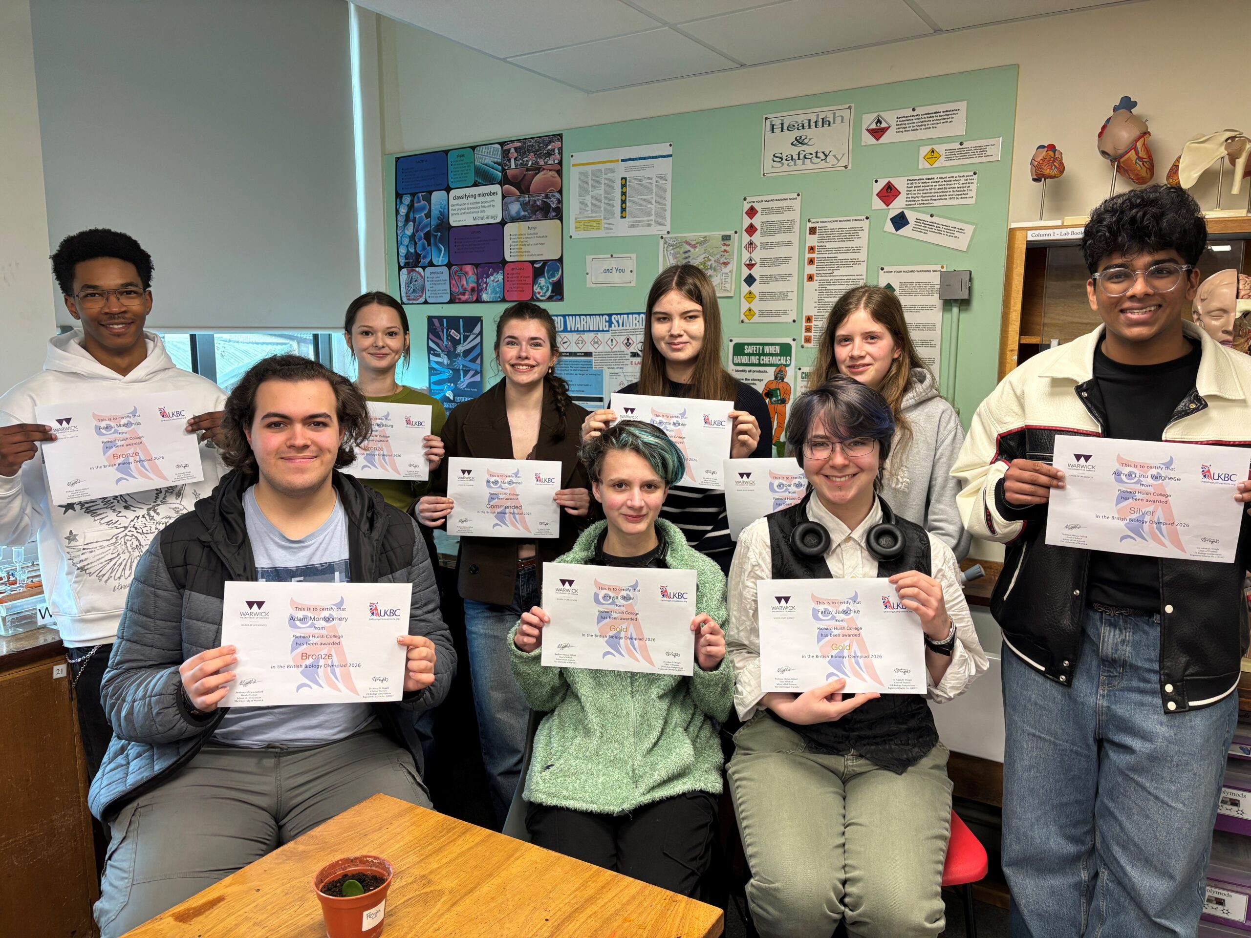 Students in lab holding certificates