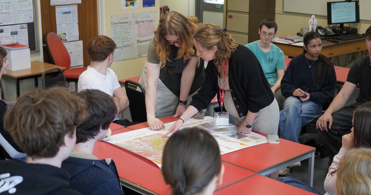 Class gathered around a map doing a task together