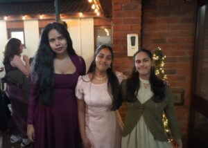 A group of students standing in a row. They are dressed formally and smiling.