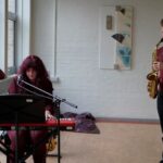 A keyboardist and a saxophonist performing music at prizegiving.