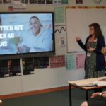 A business or university representative giving a talk in a classroom.