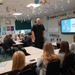 A business or university representative giving a talk in a classroom.