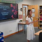 A business or university representative giving a talk in a classroom.