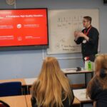 A business or university representative giving a talk in a classroom.