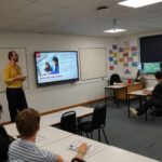 A business or university representative giving a talk in a classroom.