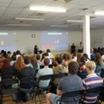 Lots of students sat down listening to a talk.