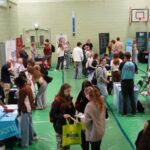 A busy careers fair, with lots of different exhibition stands.