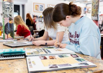 Students working on their art books in an art class.