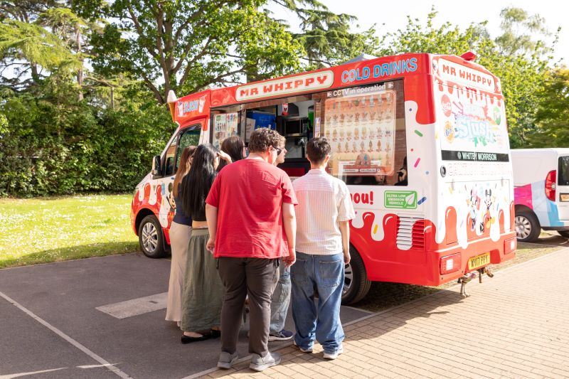 Students queuing up outside an ice cream van.